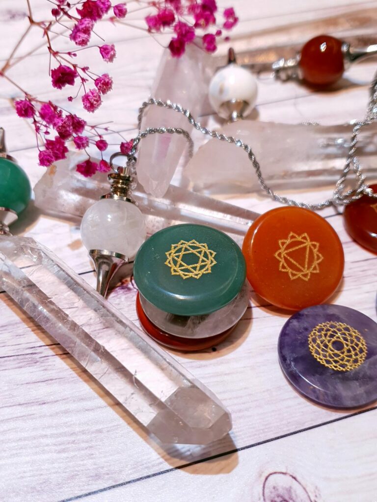 photo of crystal pendulum and chakra stones