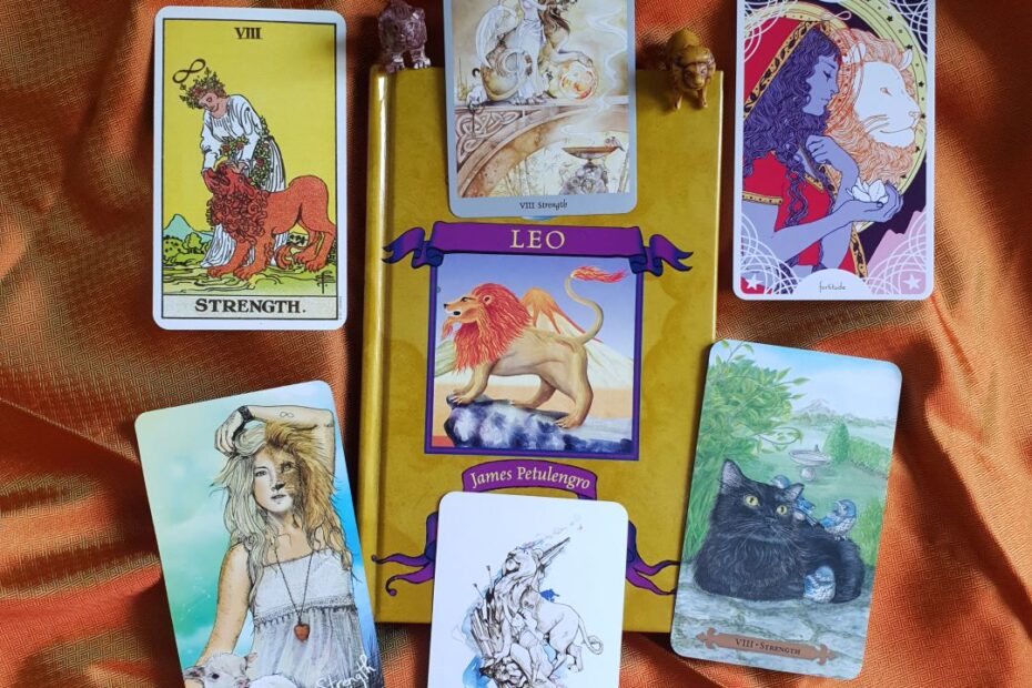 photo of strength tarot cards and a leo book for leo season