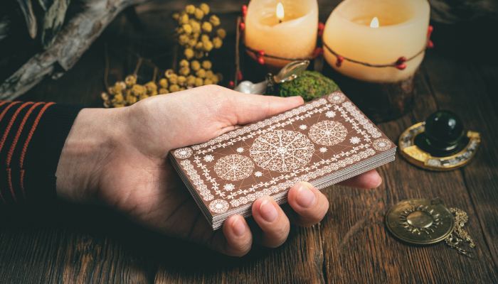 photo of a hand holding a deck of tarot cards