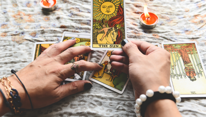 tarot reader holding the sun card from the rider waite smith tarot