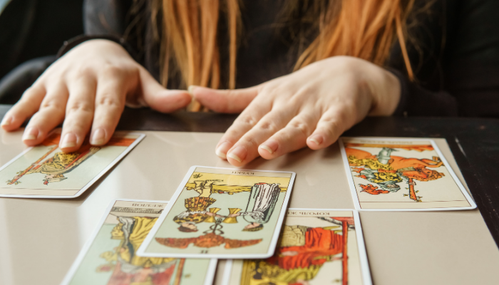 a tarot reader laying cards out for a client